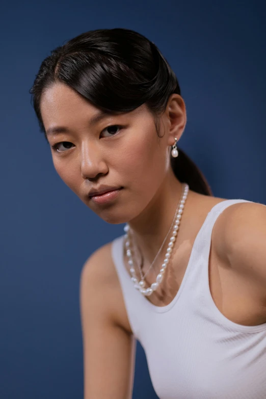 a woman in a white tank top holding a tennis racquet, inspired by Zhang Yin, photorealism, wearing pearl earrings, platinum jewellery, modeled, pearl necklace