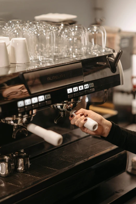 a woman standing in front of a coffee machine, by Niko Henrichon, pexels contest winner, hands on counter, gif, sparkling, a handsome