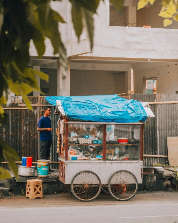 a food cart sitting on the side of a road, by Emma Andijewska, pexels contest winner, sumatraism, standing outside a house, 15081959 21121991 01012000 4k, blue, bao pnan