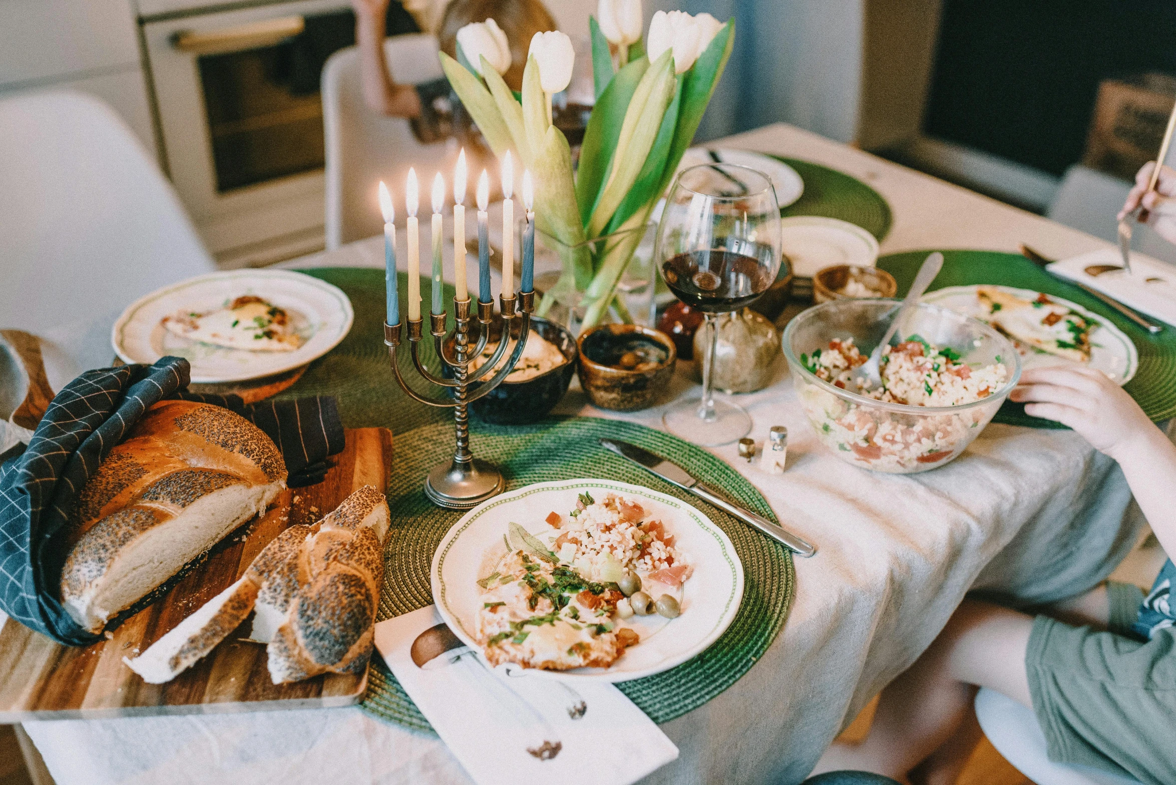 a woman sitting at a table with plates of food, pexels contest winner, renaissance, white candles, polish food, sea - green and white clothes, gif