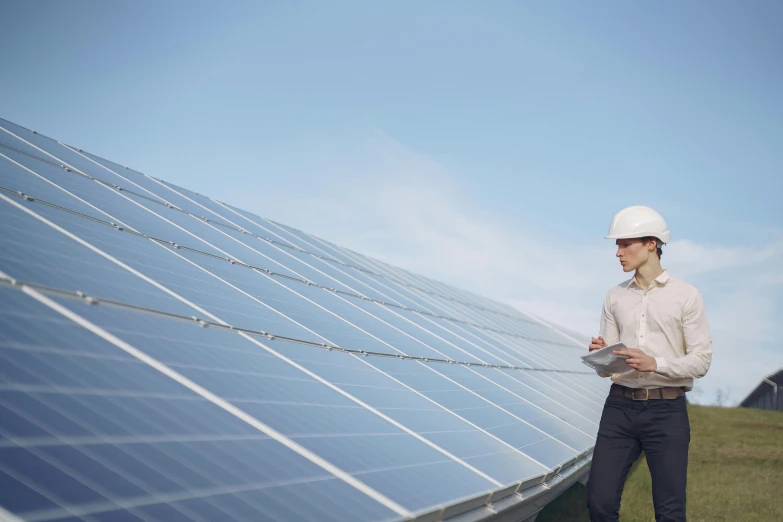 a man in a hard hat standing in front of solar panels, pexels contest winner, woman, on location, avatar image, white