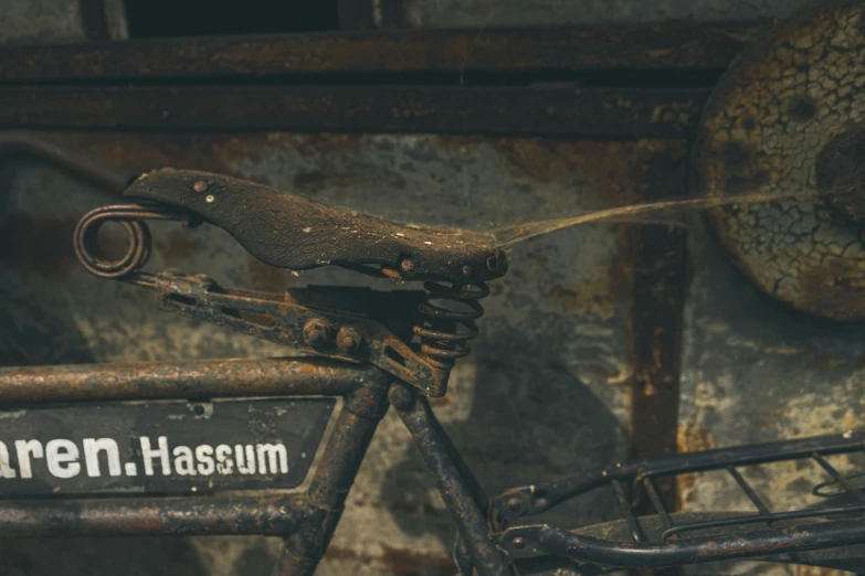 a close up of a bike parked in front of a wall, by Nils Hamm, unsplash contest winner, massurrealism, a screenshot of a rusty, blacksmith product design, in the museum, haris nukem