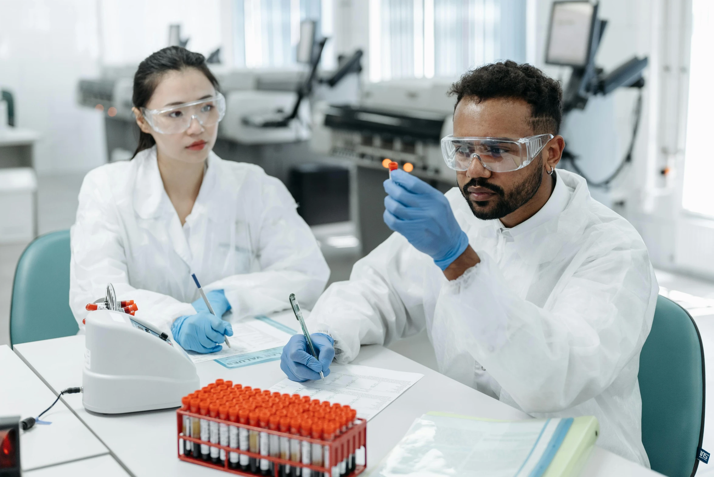 a couple of people sitting at a table in a lab