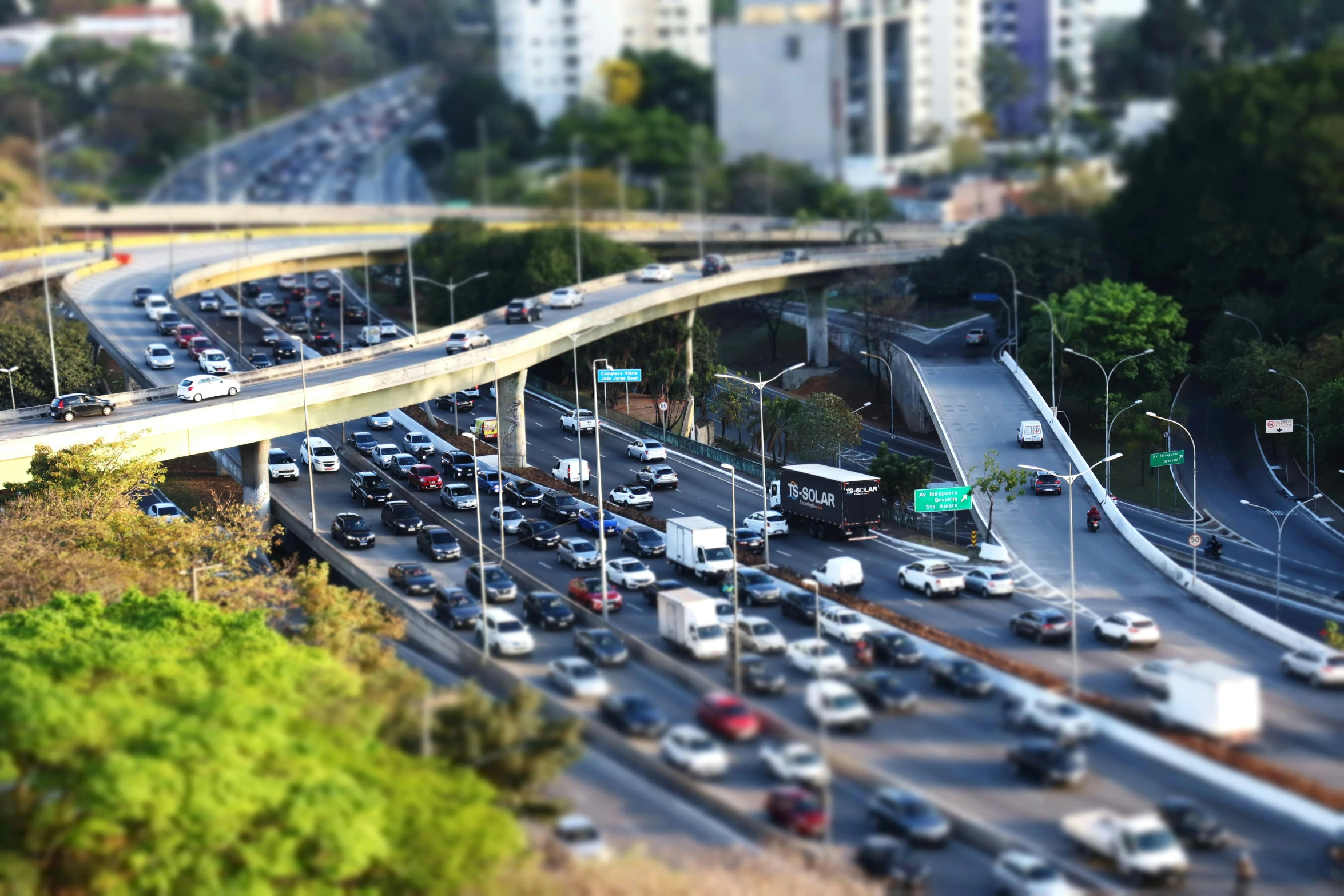 a highway filled with lots of traffic next to tall buildings, a tilt shift photo, by Alejandro Obregón, flickr, instagram post, overpass, ilustration, avatar image