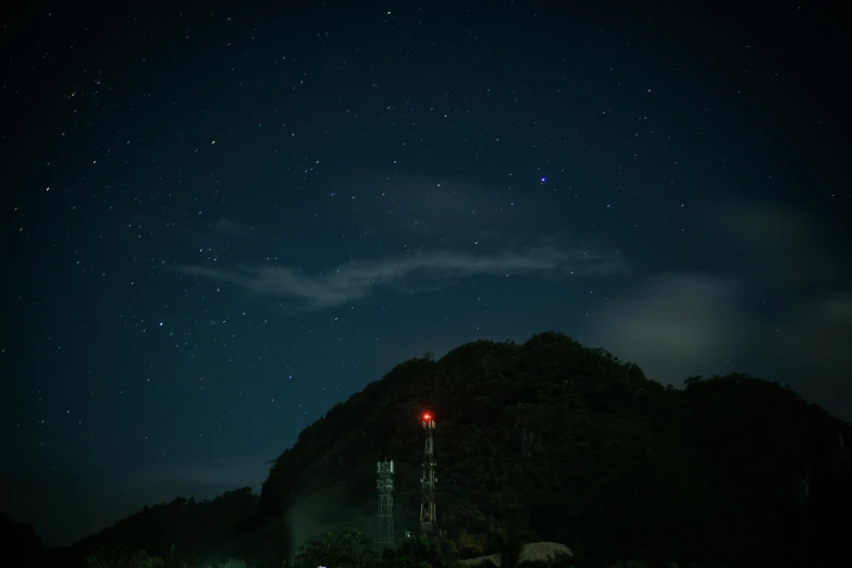 a lighthouse sitting on top of a lush green hillside, a picture, unsplash contest winner, sumatraism, black sky with stars, festival. scenic view at night, 2 5 6 x 2 5 6 pixels, cinematic shot ar 9:16 -n 6 -g
