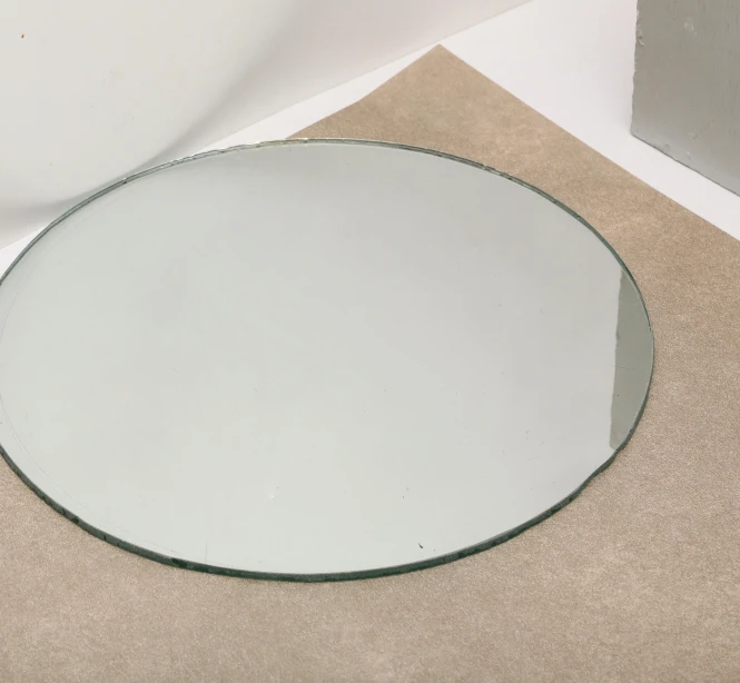 a white toilet sitting next to a round mirror, an album cover, by Nina Hamnett, bauhaus, glass texture, tabletop model, early 2 0 th century, raphaël