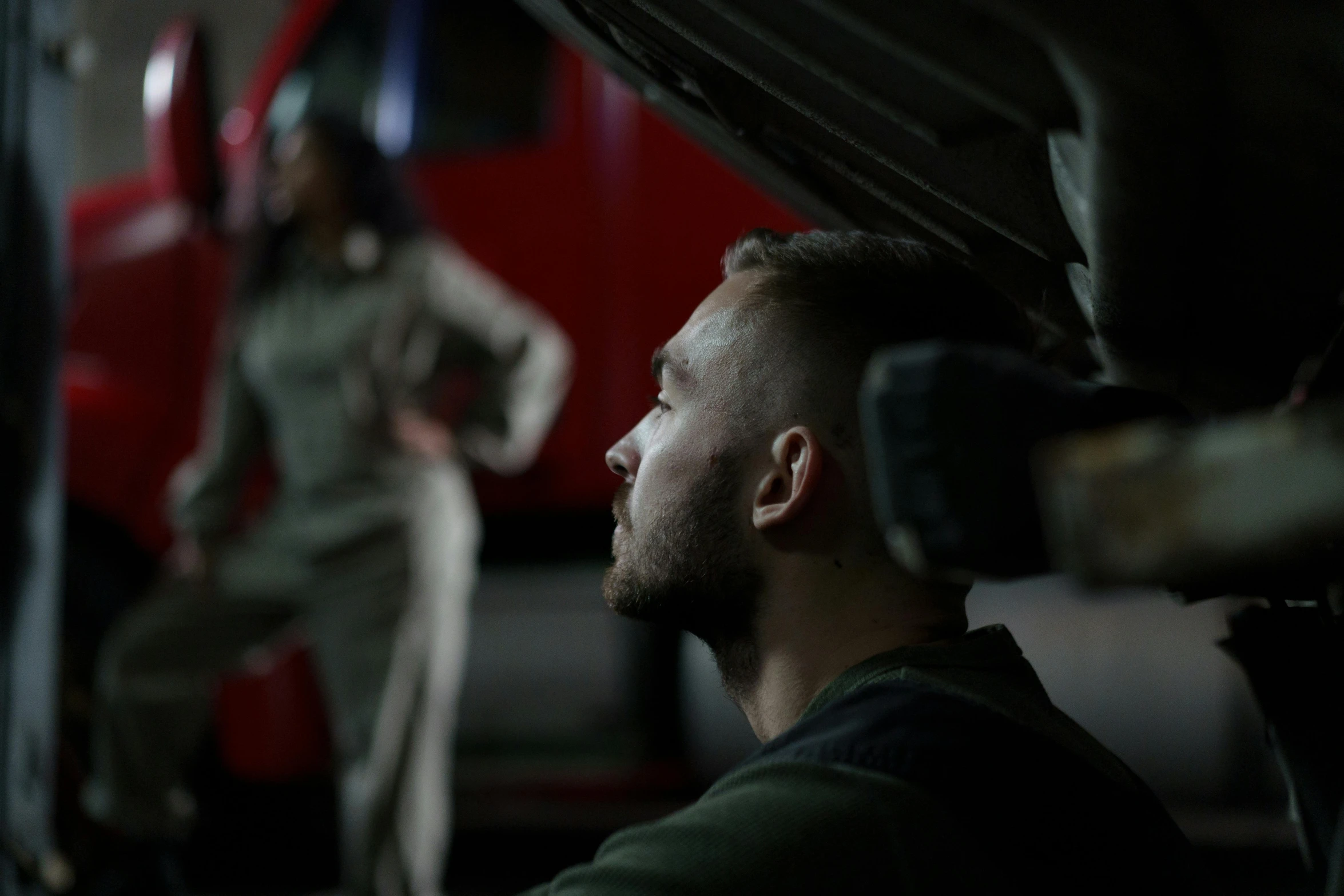 a man working on a car in a garage, pexels contest winner, military soldier behavior, medium shot of two characters, a firetruck at night, looking at monitor