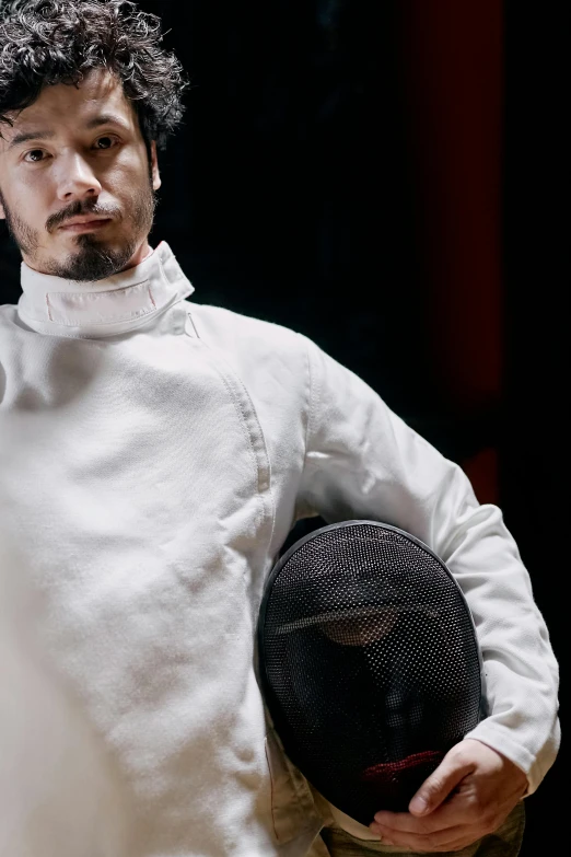 a man in a white jacket holding a fencer's mask, inspired by Kanō Eitoku, unsplash, portrait of keanu reeves, f 1, lightweight armour, technical suit