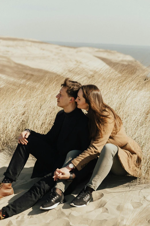 a man and woman sitting on top of a sandy hill, trending on pexels, extremely handsome, belgium, 'wherever you go, cinematic lut