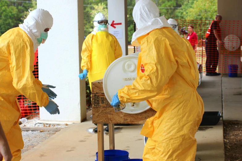 a group of people in yellow hazmat suits, hurufiyya, carrying a tray, splash image, thumbnail