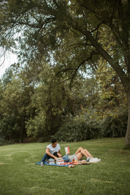 a group of people sitting on top of a lush green field, reading under a tree, napa, lesbians, jc park