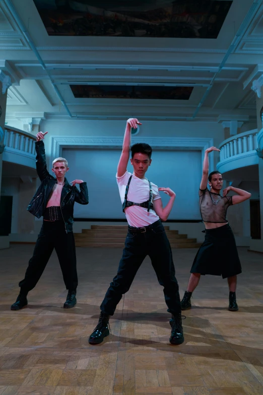 a group of people standing on top of a wooden floor, antipodeans, classic dancer striking a pose, non-binary, 3 actors on stage, damien tran