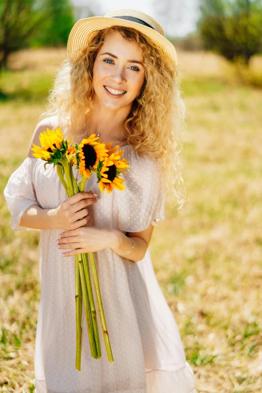 a woman holding a bunch of sunflowers in a field, a picture, shutterstock, renaissance, blonde curly hair, beautiful portrait image, smiling fashion model, square