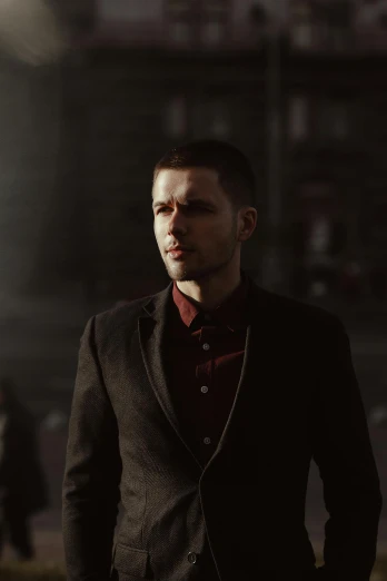 a man in a suit standing in front of a building, inspired by Niko Henrichon, diffuse cinematic lighting, **cinematic, a man wearing a black jacket, moody scene