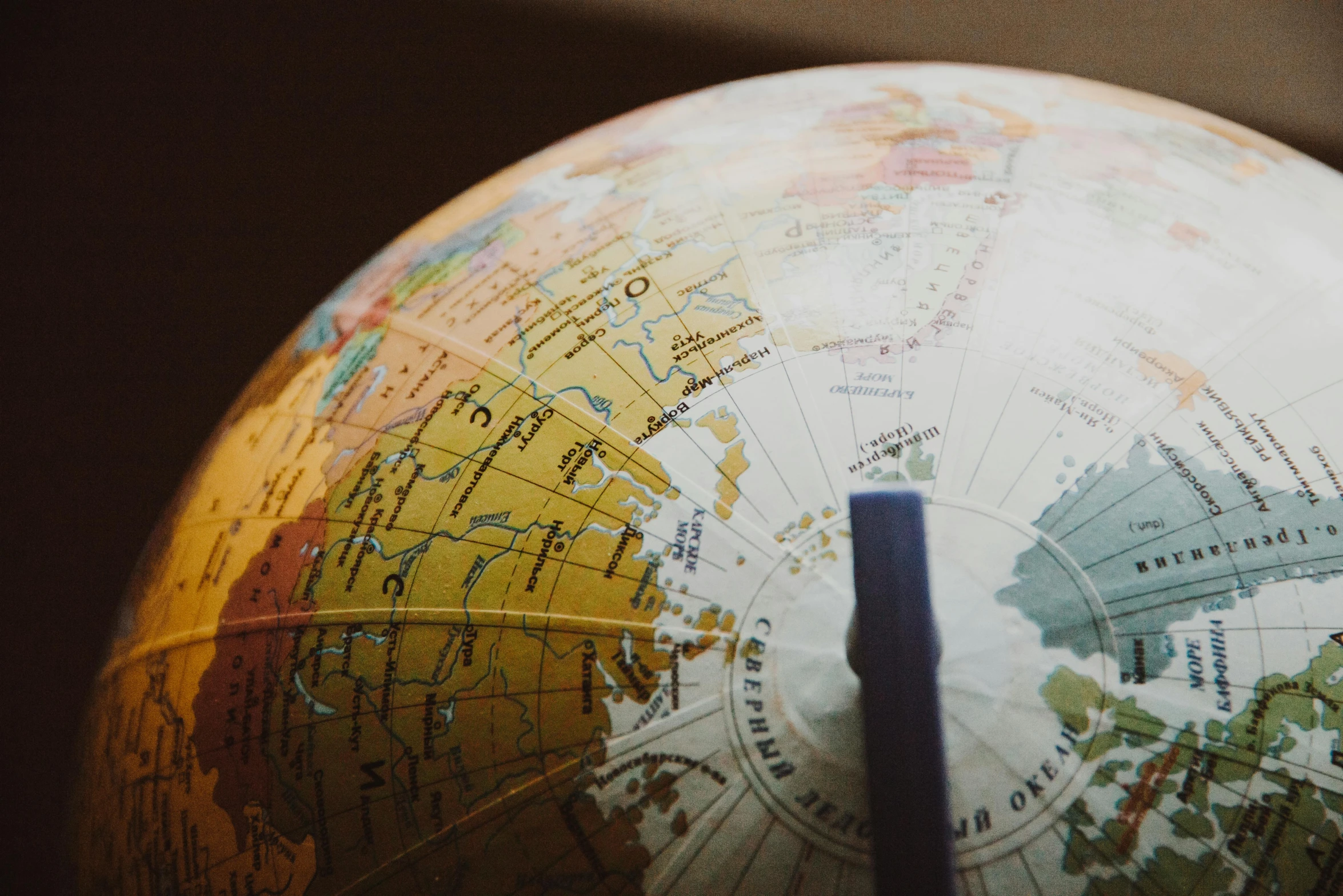 a globe with a blue stick sticking out of it, trending on unsplash, ivory, yellow, brown, schools