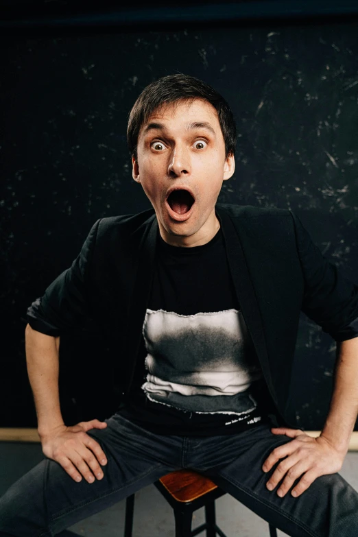 a man sitting on a stool with his mouth open, inspired by Alexander Kanoldt, pexels contest winner, wearing a shirt, anton fedeev, huge surprised eyes, colin greenwood (bass)