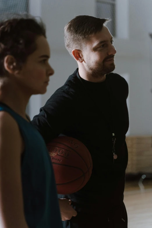 a man standing next to a woman holding a basketball, profile image, demna gvasalia, shot from the back, local gym