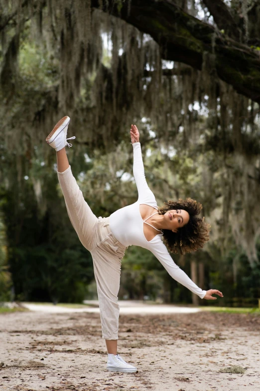 a woman doing a yoga pose in front of a tree, inspired by Elizabeth Polunin, pexels contest winner, arabesque, in savannah, wavy hair spread out, males and females breakdancing, white