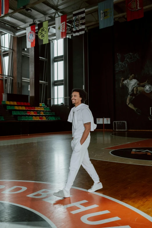 a man standing on top of a basketball court, an album cover, pexels contest winner, happening, white uniform, giorgio a. tsoukalos, indoor picture, wide full body