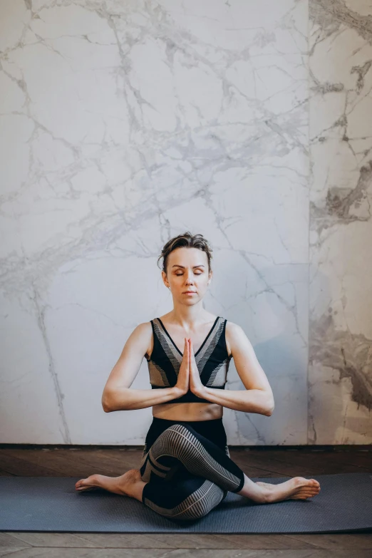 a woman sitting in the middle of a yoga pose, pexels contest winner, renaissance, on a large marble wall, low quality photo, serene expression, in a gym