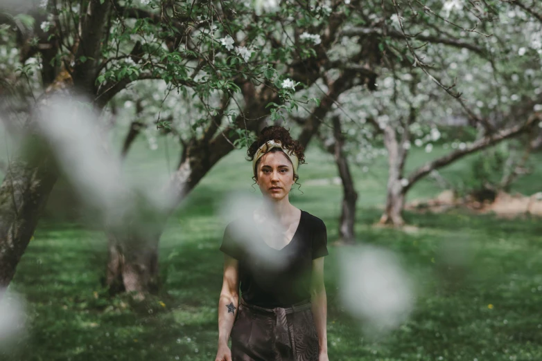 a woman standing in a field surrounded by trees, a portrait, inspired by Elsa Bleda, pexels contest winner, renaissance, blossoms, introspective meandering, center focused, person made of tree