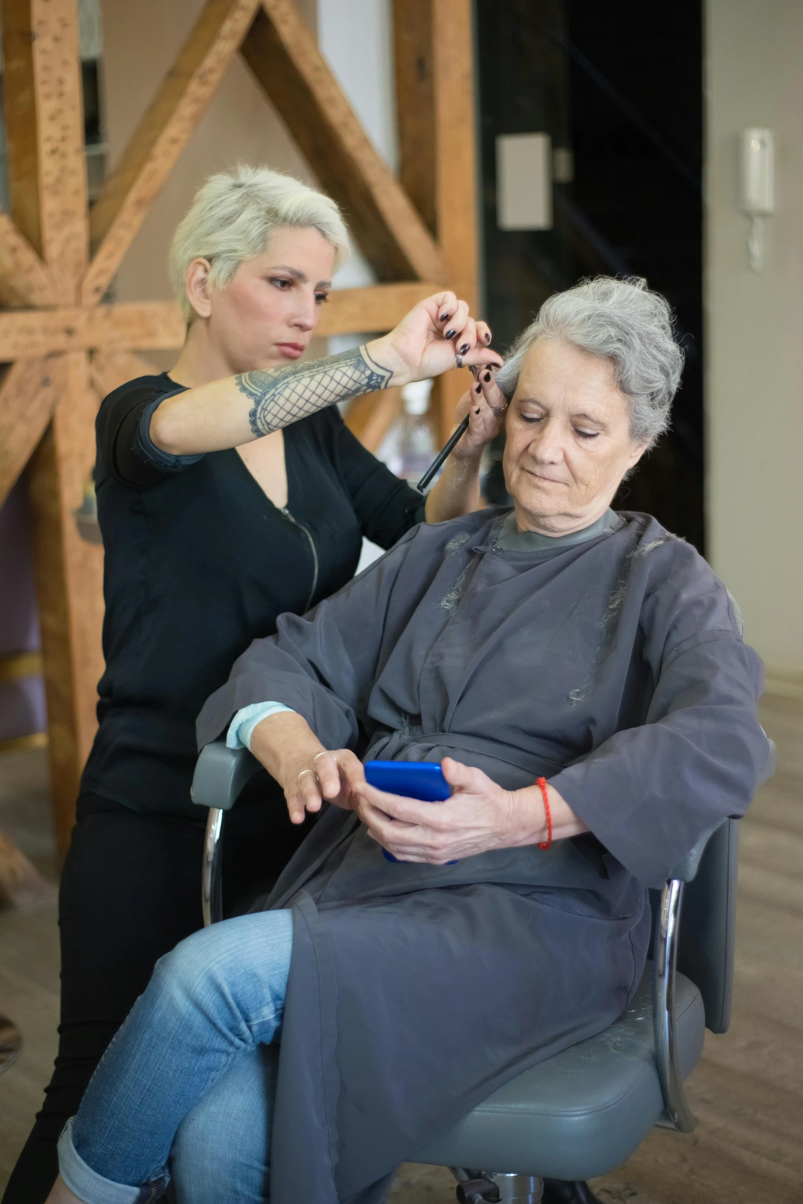 a woman sitting in a chair cutting another woman's hair, short grey hair, ready to model, uploaded, aging