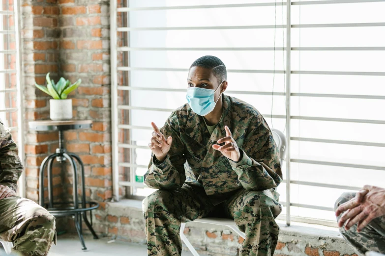 a group of soldiers sitting next to each other, pexels contest winner, hurufiyya, medical mask, looking to his side, lgbtq, sitting on a table