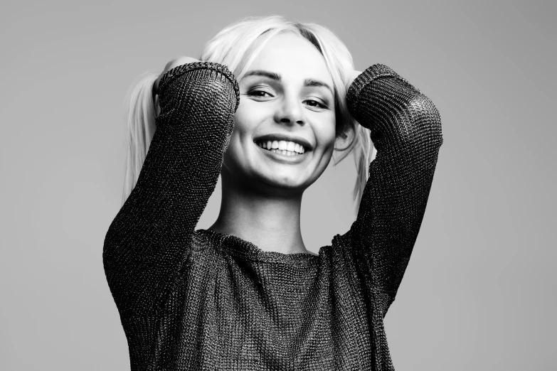 a black and white photo of a woman smiling, inspired by Louisa Matthíasdóttir, pexels, antipodeans, die antwoord yolandi visser, wearing casual sweater, neon operator margot robbie, arms extended