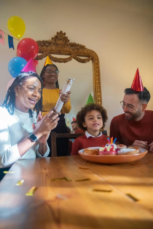 a group of people sitting around a table at a birthday party, caring fatherly wide forehead, promo image, families playing, high quality upload