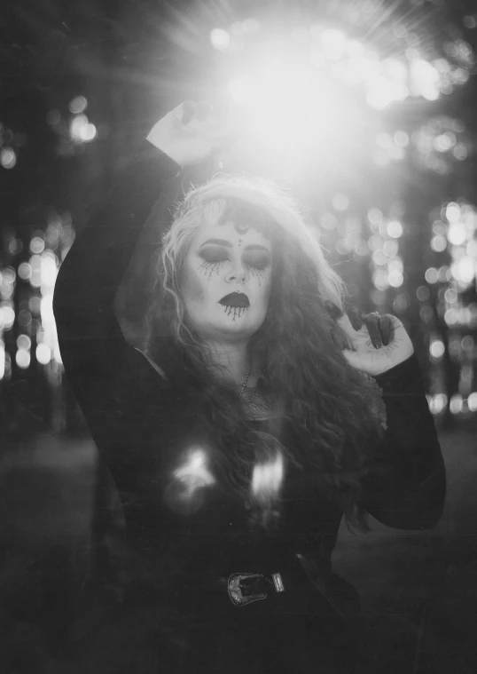 a black and white photo of a woman with long hair, a black and white photo, inspired by Kati Horna, tumblr, gothic art, glowing lens flare wraith girl, dark makeup, witchlight carnival, brandon woelfel