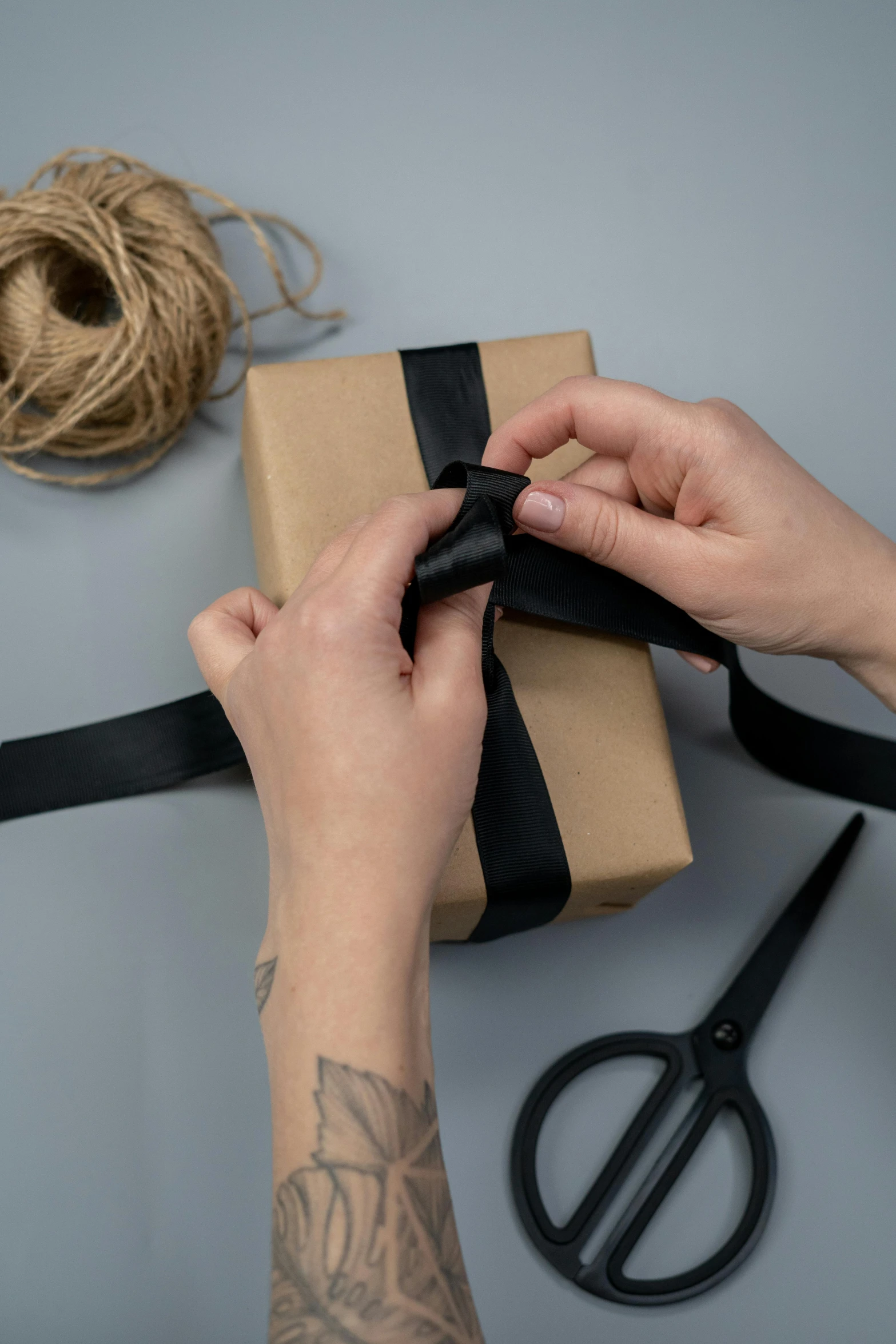 a person wrapping a gift with a black ribbon, by Eden Box, extra wide, craft, brown, labels