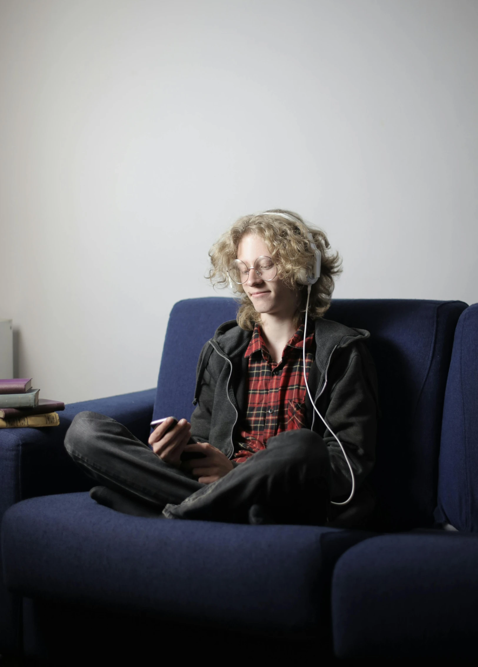 a person sitting on a couch with headphones on, by Jakob Emanuel Handmann, happening, pale skin curly blond hair, student, transparent, young commoner