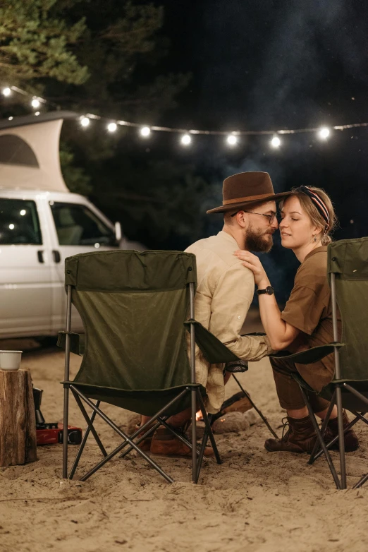 a man and woman sitting in lawn chairs in front of a camper, by Niko Henrichon, trending on pexels, renaissance, firefly lights, man and woman in love, wearing a straw hat and overalls, vehicle