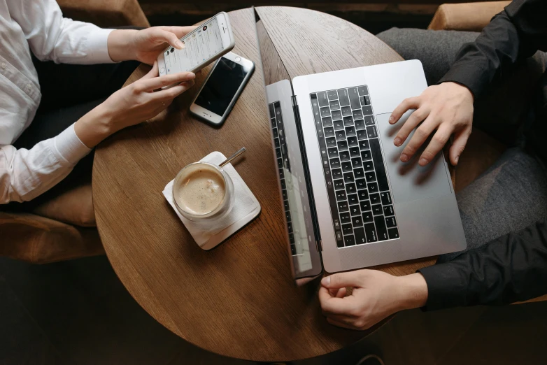 a couple of people sitting at a table with laptops, trending on pexels, sitting on a mocha-colored table, handheld, 15081959 21121991 01012000 4k, thumbnail