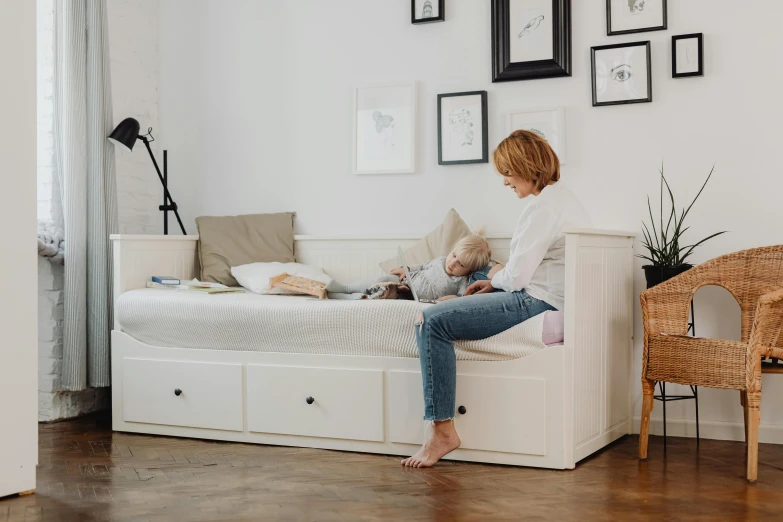 a woman sitting on a bed with a teddy bear, a cartoon, by Ruth Simpson, trending on pexels, ikea catalogue photo, couch desk, white finish, with a kid