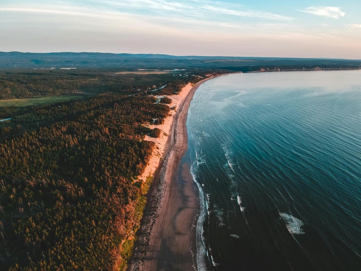 a large body of water next to a beach, by Daniel Lieske, pexels contest winner, les nabis, quebec, wide high angle view, summer evening, thumbnail