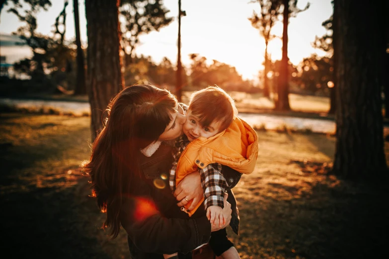 a woman holding a baby in her arms, pexels contest winner, golden hour hues, avatar image, cute boy, manuka