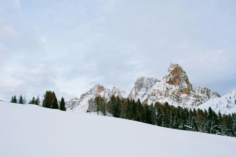 a man riding skis down a snow covered slope, pexels contest winner, cypresses and hills, photographic print, dolomites, a cozy