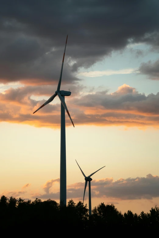 a couple of wind turbines sitting on top of a lush green field, by Jesper Knudsen, sunset!, best photo, full frame image, multiple stories