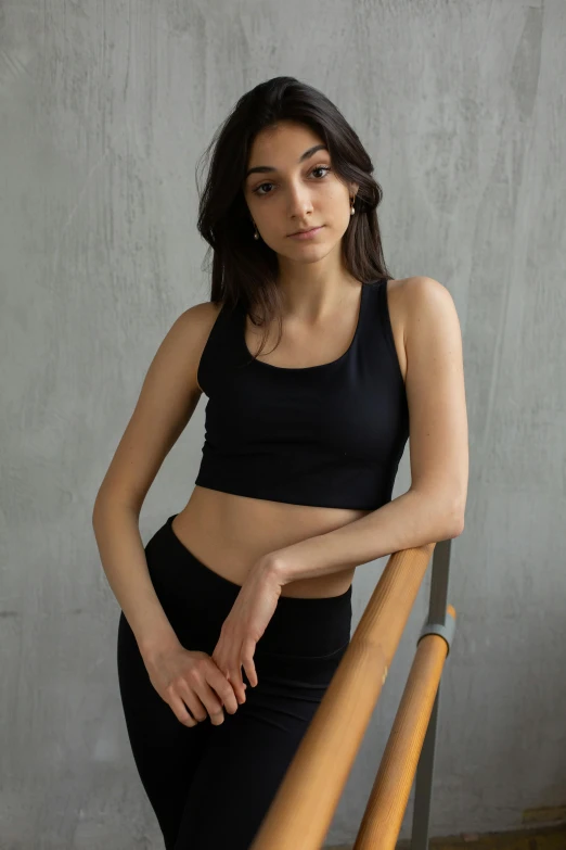 a woman standing at the top of a flight of stairs, inspired by Elizabeth Polunin, renaissance, wearing a cropped black tank top, official product photo, soft natural light, cute sportswear