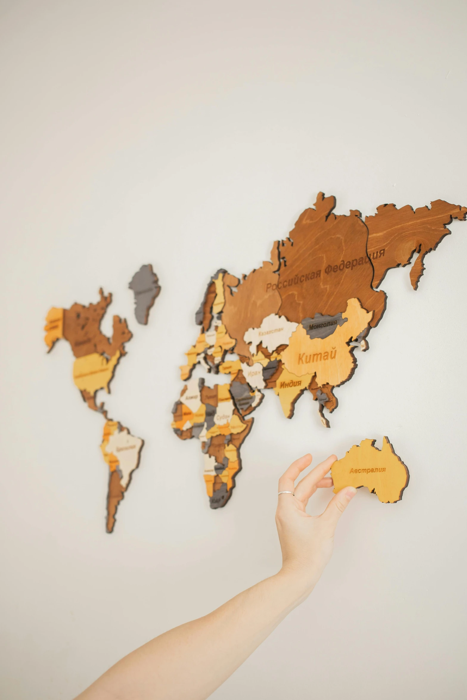 a person pointing to a world map on a wall, a jigsaw puzzle, by Will Ellis, interactive art, wooden art toys on base, brown colours, orange, mapbox