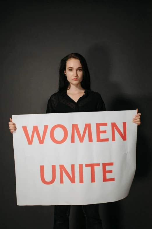 a woman holding a sign that says women unite, a poster, by Arabella Rankin, shutterstock, alessio albi, high quality picture, studio photo, multi-part