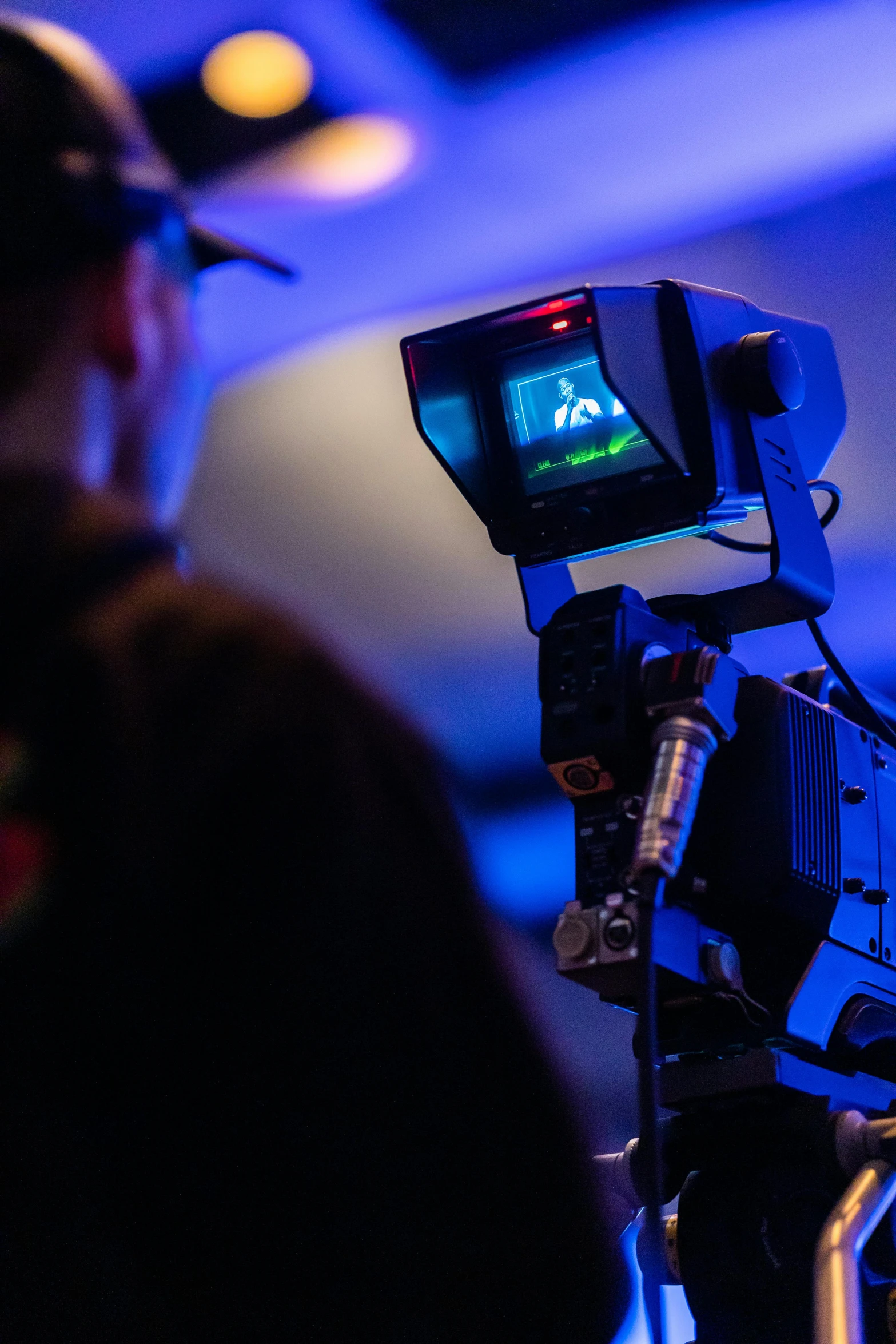 a man standing in front of a video camera, by Greg Rutkowski, siggraph, close-up shot from behind, soft lighting sold at an auction, robotics