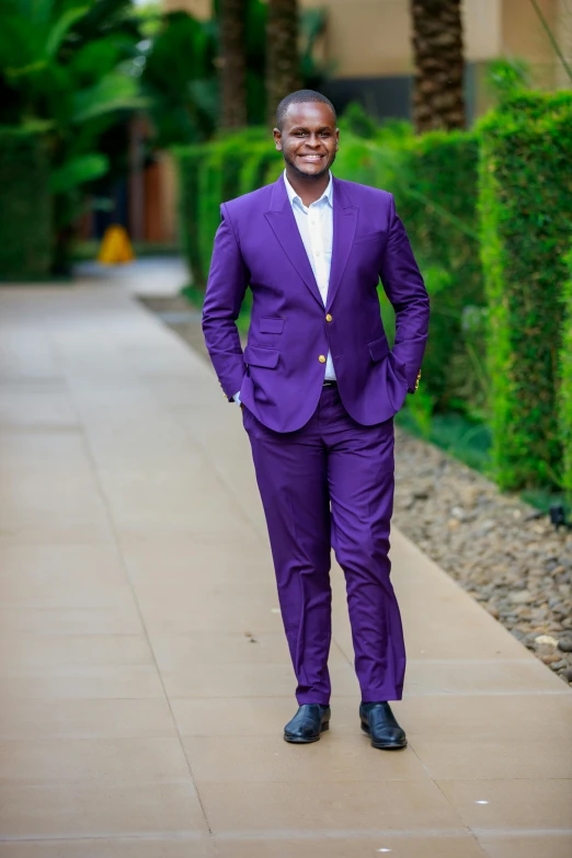 a man in a purple suit standing on a sidewalk, an album cover, inspired by Charles Alston, pexels, full - body - front - shot, full colored, at home, tailored clothing