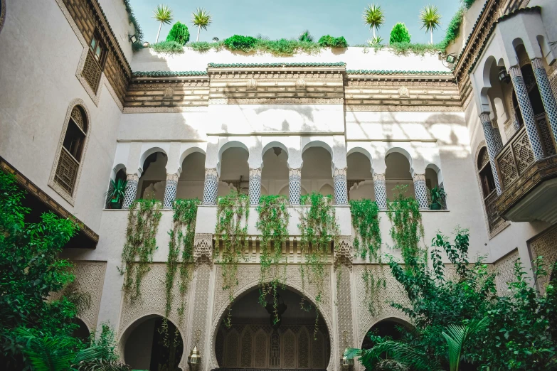 a building that has a bunch of plants on top of it, a photo, inspired by Riad Beyrouti, pexels contest winner, arabesque, white sweeping arches, a green, profile image, group photo