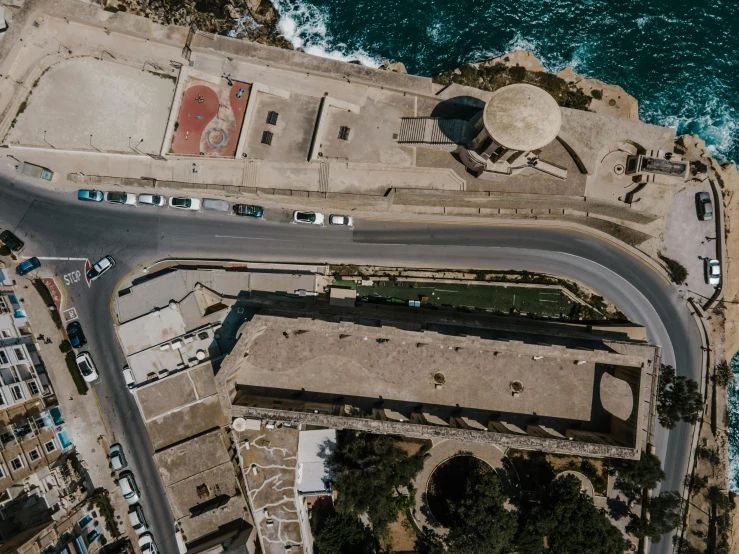 an aerial view of a parking lot next to the ocean, pexels contest winner, les nabis, city walls, military buildings, silo, detailed high resolution