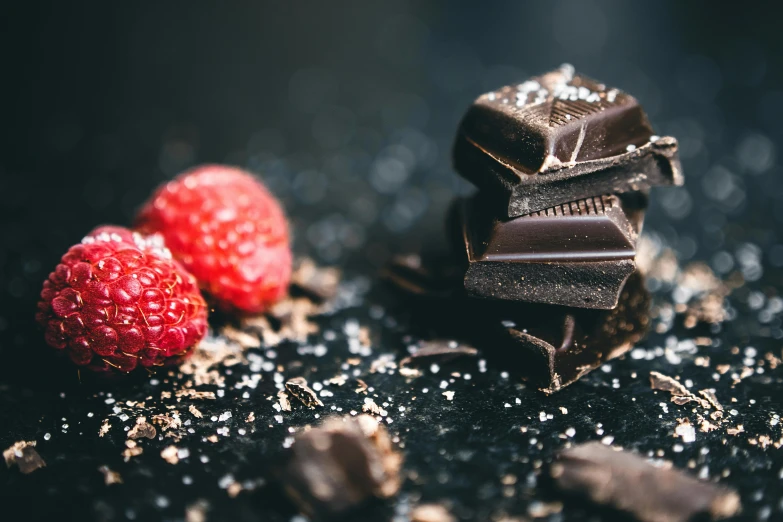 a pile of chocolate and raspberries on a table, unsplash, sparkling, magnesium, deep black, 🎀 🗡 🍓 🧚