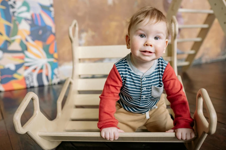 a baby sitting on top of a wooden bed, sitting in a rocking chair, activity play centre, jakub kasper, thumbnail