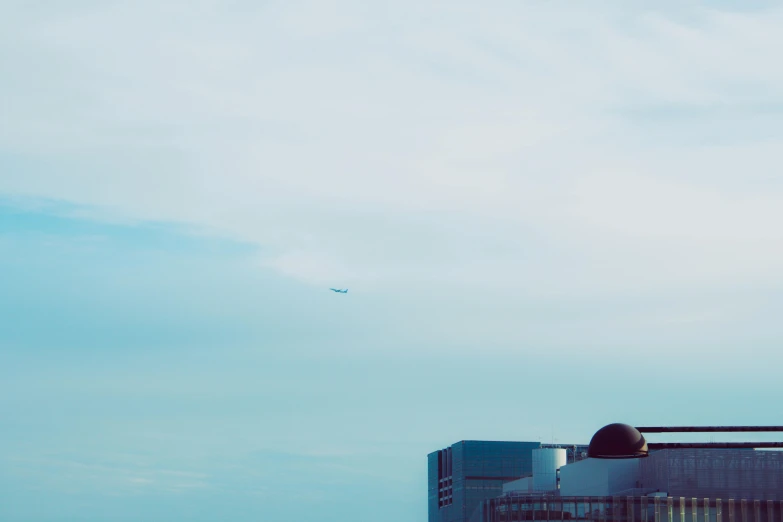 a couple of people that are sitting on a bench, a photo, inspired by Richard Wilson, minimalism, airplane in the sky, 35mm —w 1920 —h 1080, lone industrial!!! spaceship!!, flying in the air over city