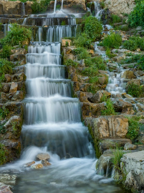 a waterfall flowing through a lush green forest, by Arnie Swekel, pexels contest winner, renaissance, gardens and fountains, today\'s featured photograph 4k, staggered terraces, water wheel
